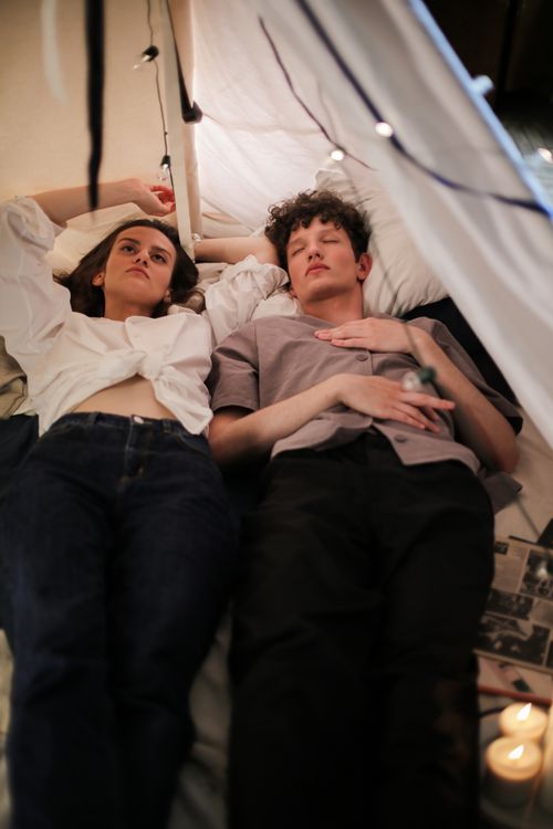 Free A young couple enjoys a peaceful moment in a cozy indoor tent setting. Stock Photo