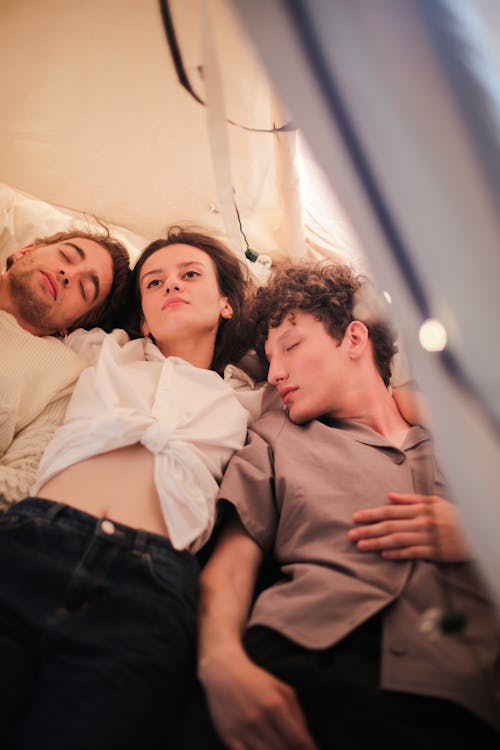 Man in Brown Button Up Shirt Lying Beside Woman in Black Denim Jeans