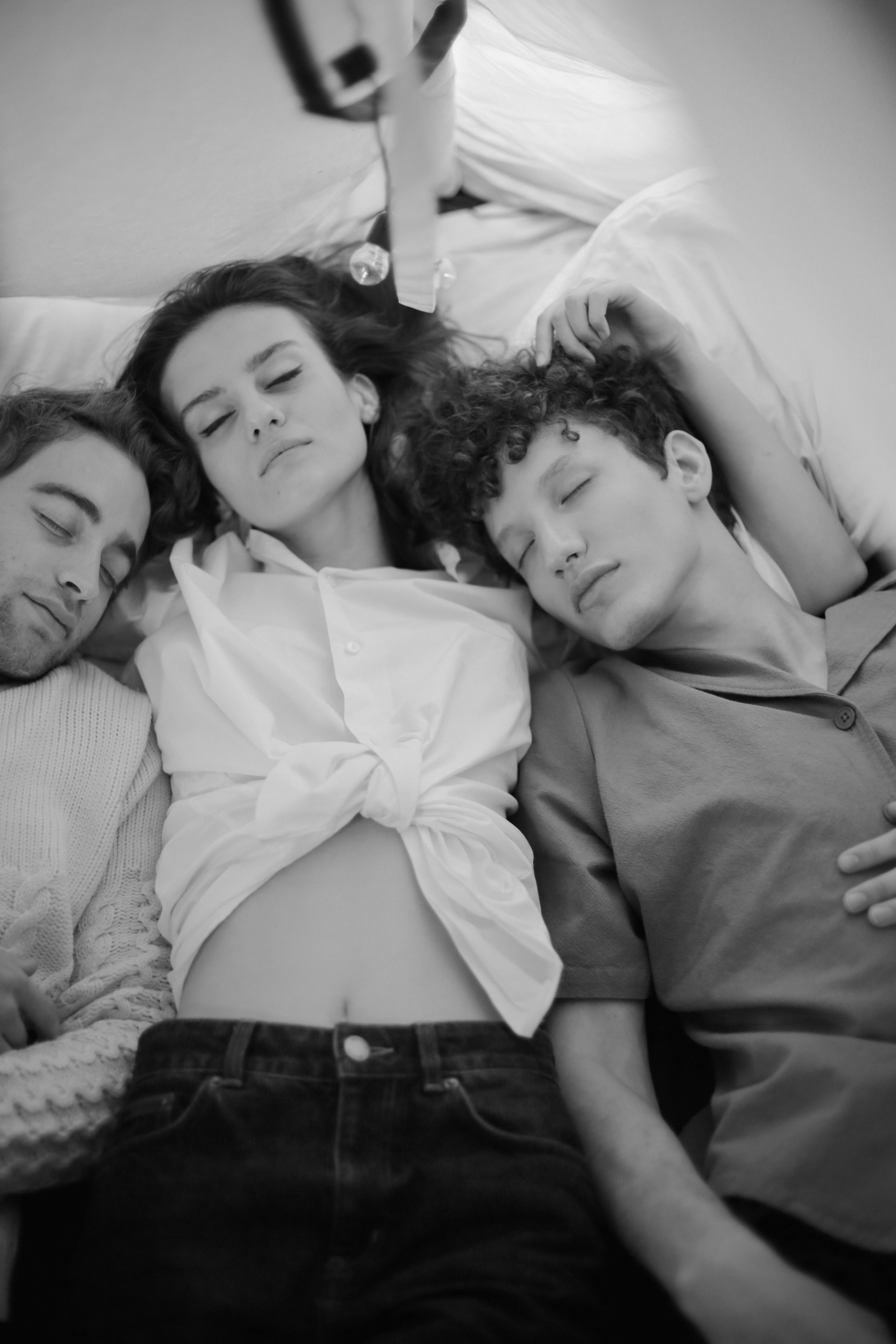 grayscale photo of man and woman lying on bed