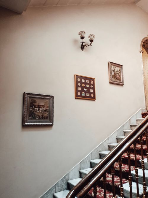 Free Interior of stylish house with stairway with red carpet and wooden railing and paintings on wall Stock Photo