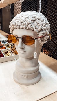 Classical bust wearing sunglasses on display in a stylish retail store.