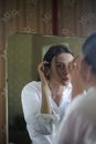 一位女士在镜子前摆出造型，展现出70年代的复古魅力