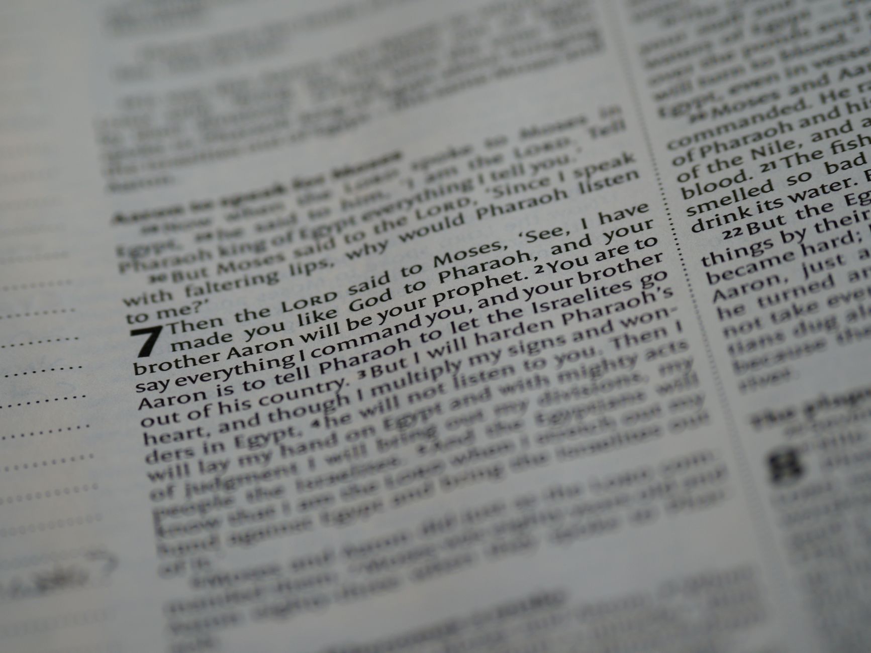 Close-up view of a Bible page highlighting scripture text with focus on verse numbers.