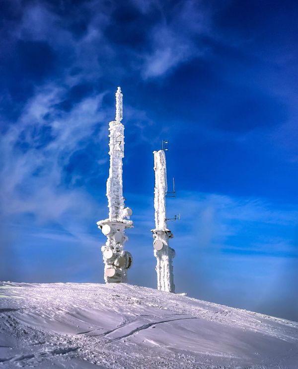 Telecom towers covered in snow on hilltop