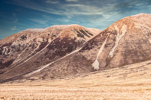 Stunning desert mountains with snow-covered peaks under a clear blue sky.