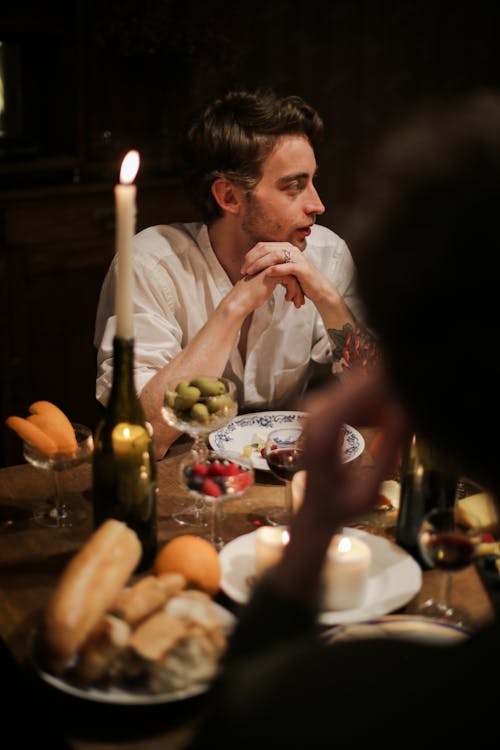 Man in White Shirt Sitting at Table