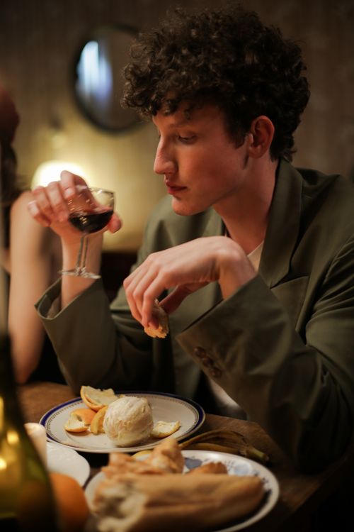 Free A man enjoying a refined dining experience with wine during an elegant evening. Stock Photo