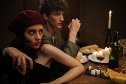 Free A romantic candlelit dinner with a couple enjoying a cozy evening. Parisian vibes and intimate setting. Stock Photo