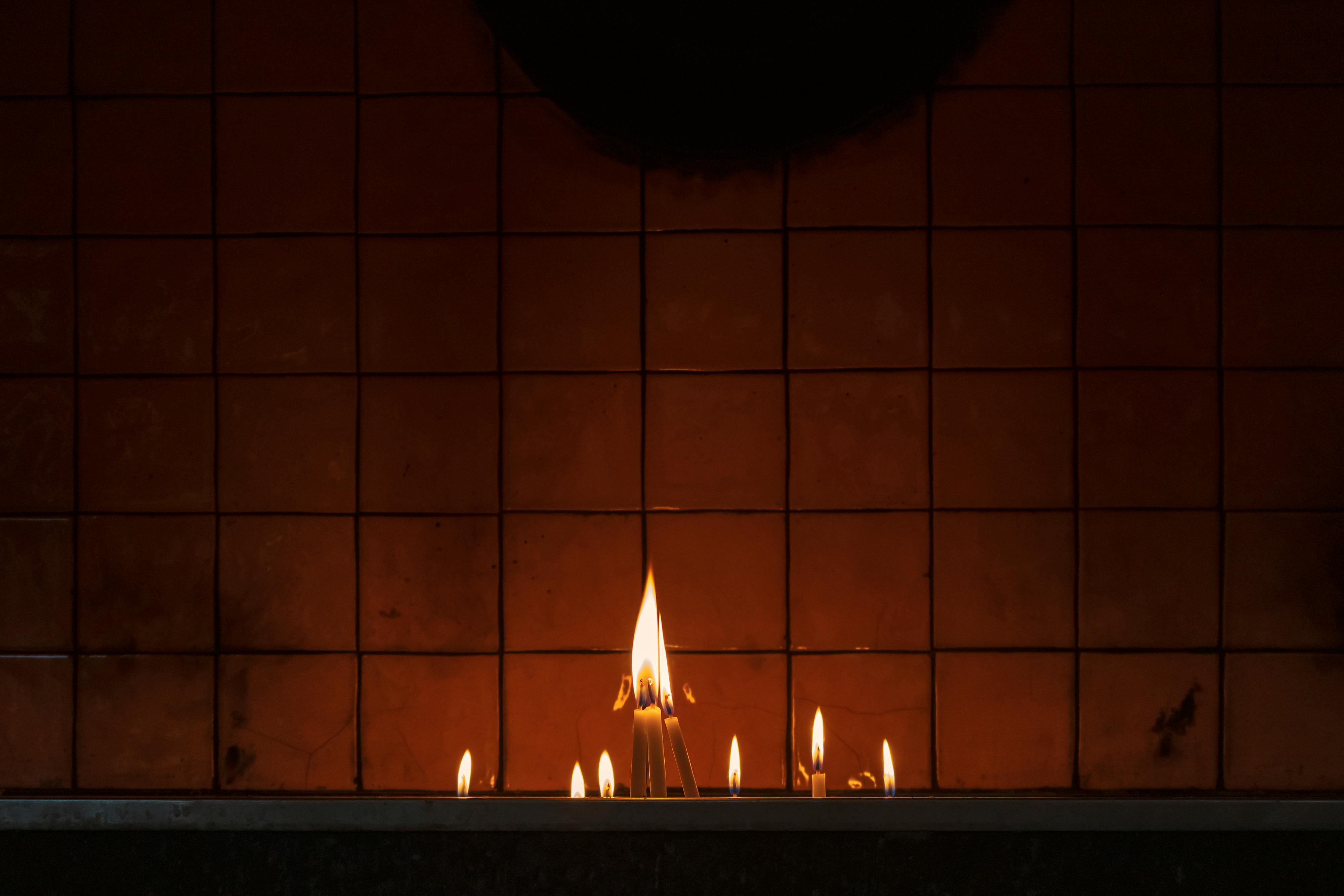 Lighted Candles on Brown Brick Wall · Free Stock Photo