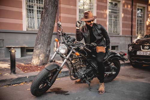 Free 검은 색 가죽 재킷과 검은 색 오토바이를 타는 갈색 모자를 입은 남자 Stock Photo
