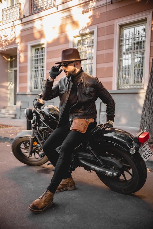 A Fashionable Man Posing while Sitting on a Motorcycle