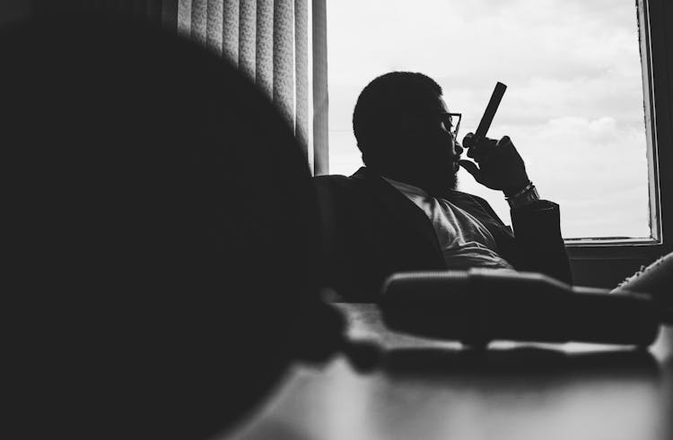 Stylish Thoughtful Businessman With Cigar In Office