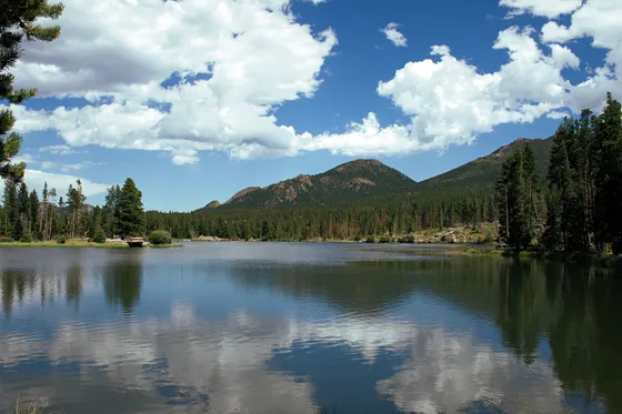 A family at Bear Lake below snowy peaks in Rocky Mountain National Park