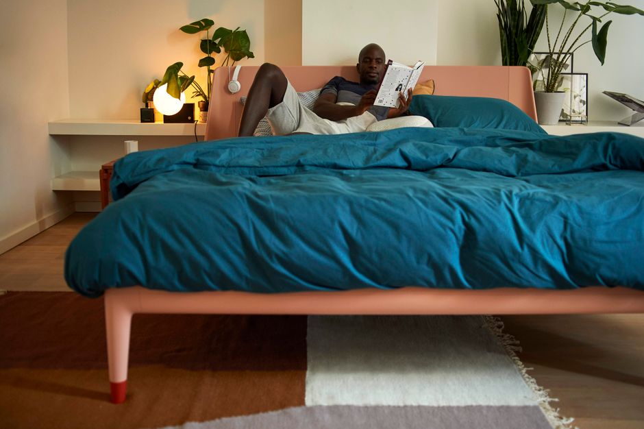 Purple Hybrid vs Casper Original: Firmness and Pressure Relief Compared Man comfortably reading a book in a stylish, cozy bedroom setting.