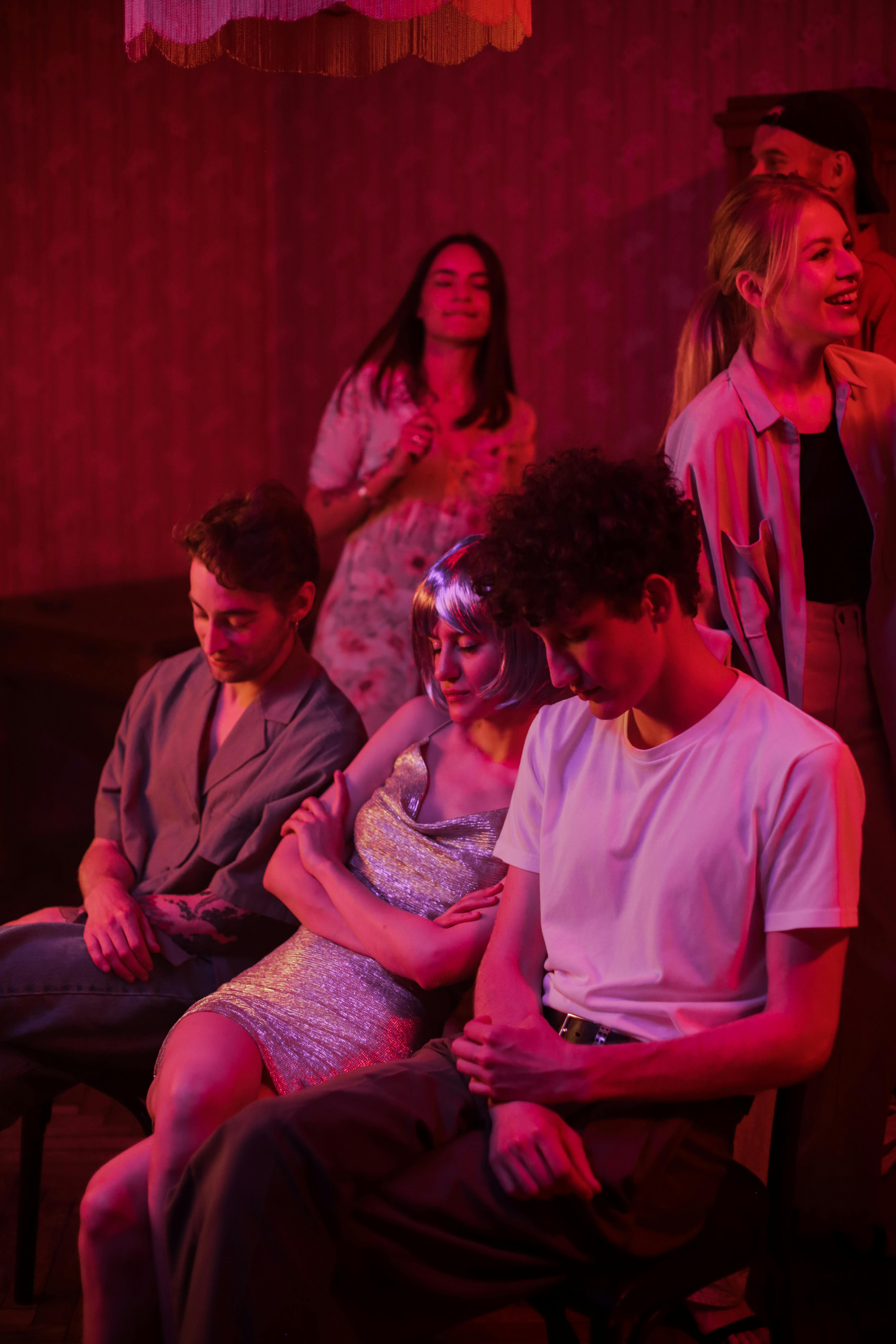 Free Youthful group enjoying a lively night party illuminated by neon lights. Stock Photo