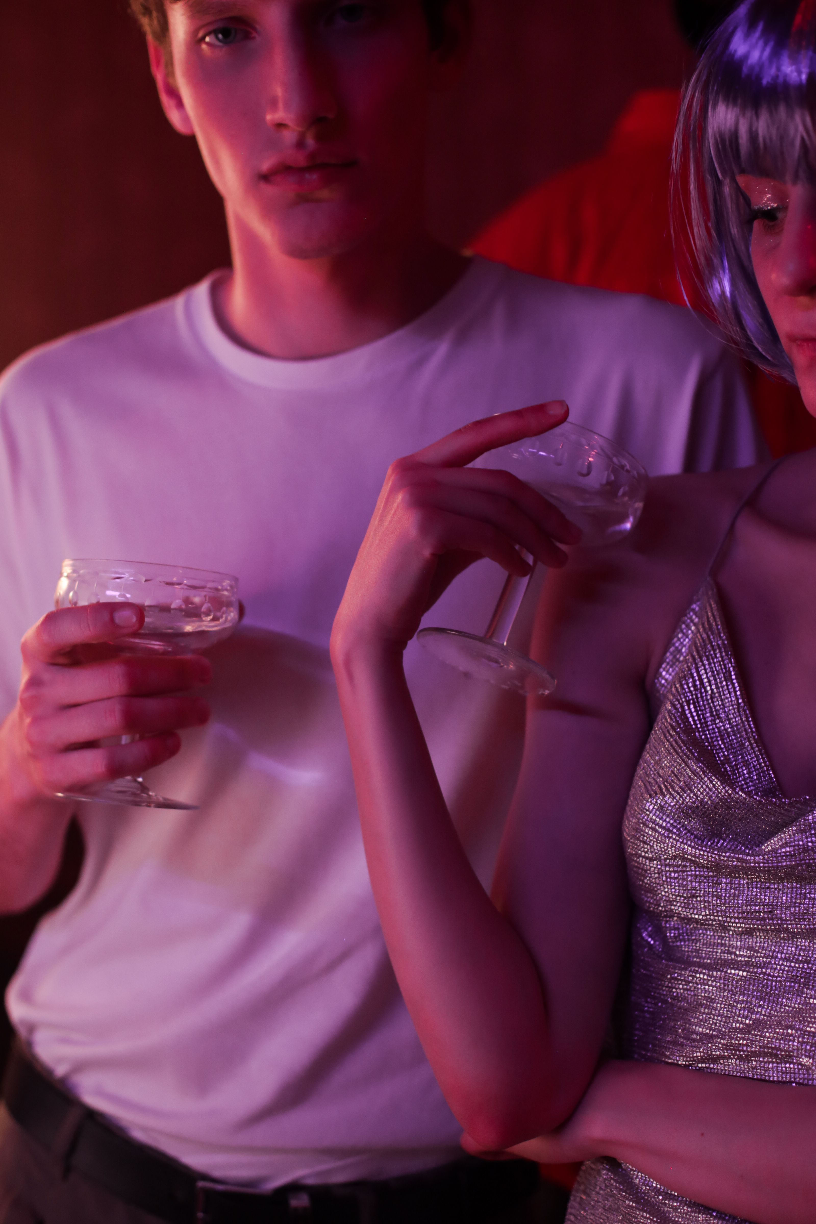 时尚的年轻人手持香槟杯，在热闹的夜生活氛围中尽情享受