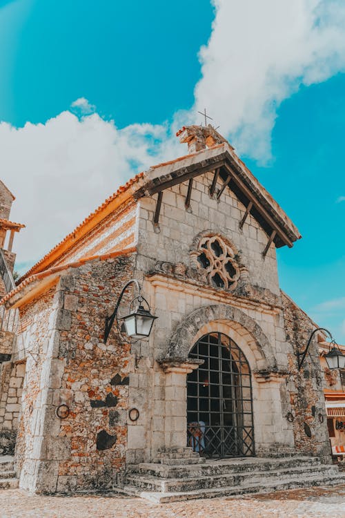 Old stone church facade under blue cloudy sky