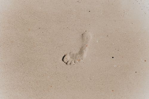 Free Top view of footprint on brown sandy coast with loose texture in daytime Stock Photo