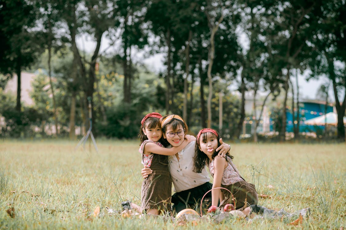 Happy Asian mother with children in park