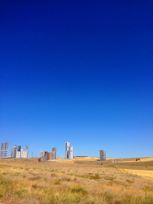 Бесплатное стоковое фото с вертикальный выстрел, высотные здания, голубое небо