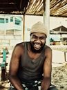 Black man laughing under roof