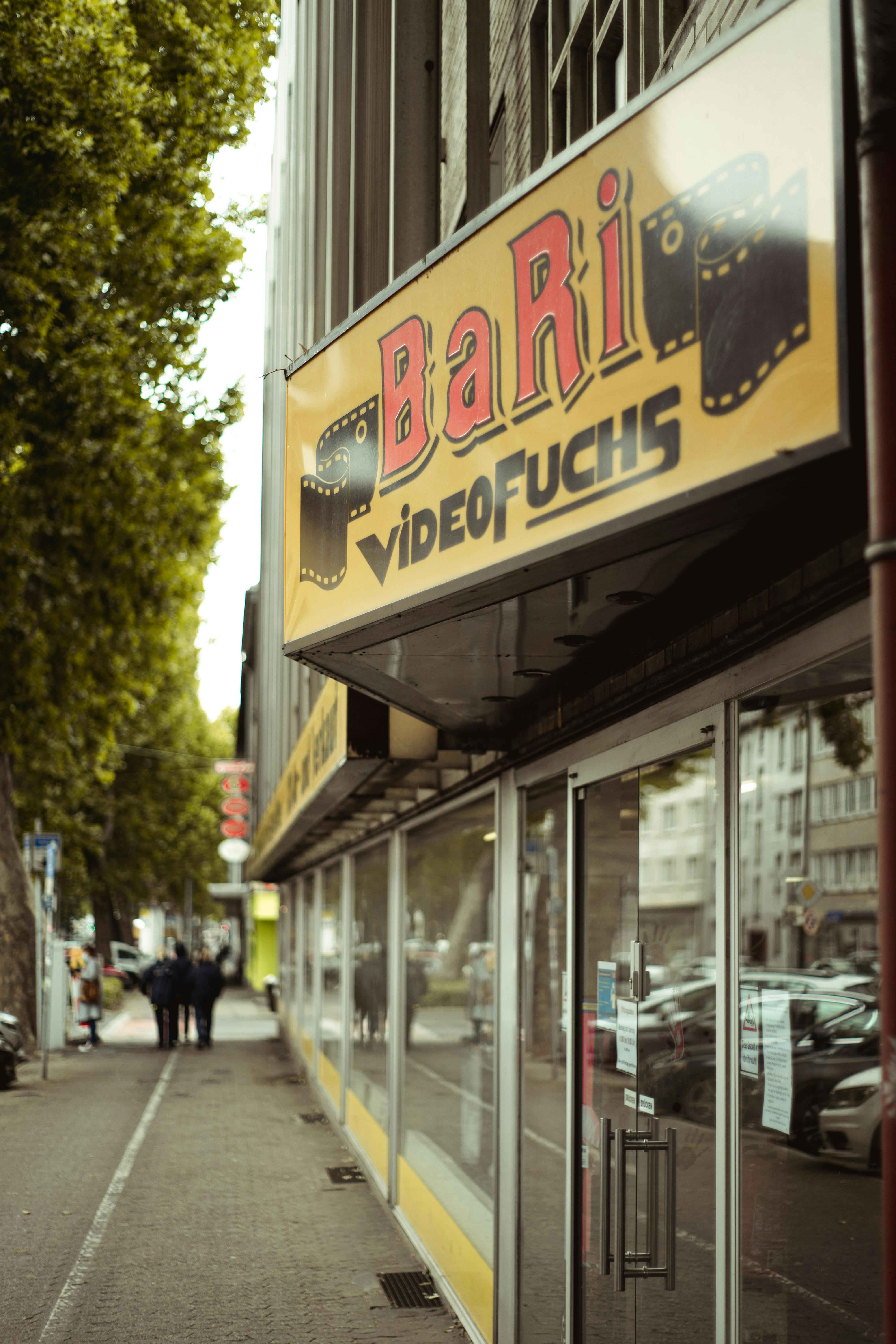 a storefront with a glass window by the sidewalk