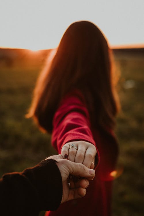 Couple holding hands in sunny field
