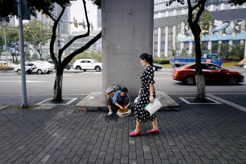 A Woman in Polka Dot Dress Waling on the Sidewalk