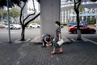 A Woman in Polka Dot Dress Waling on the Sidewalk