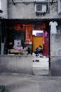 A Woman Sitting at the Door of a Concrete Building