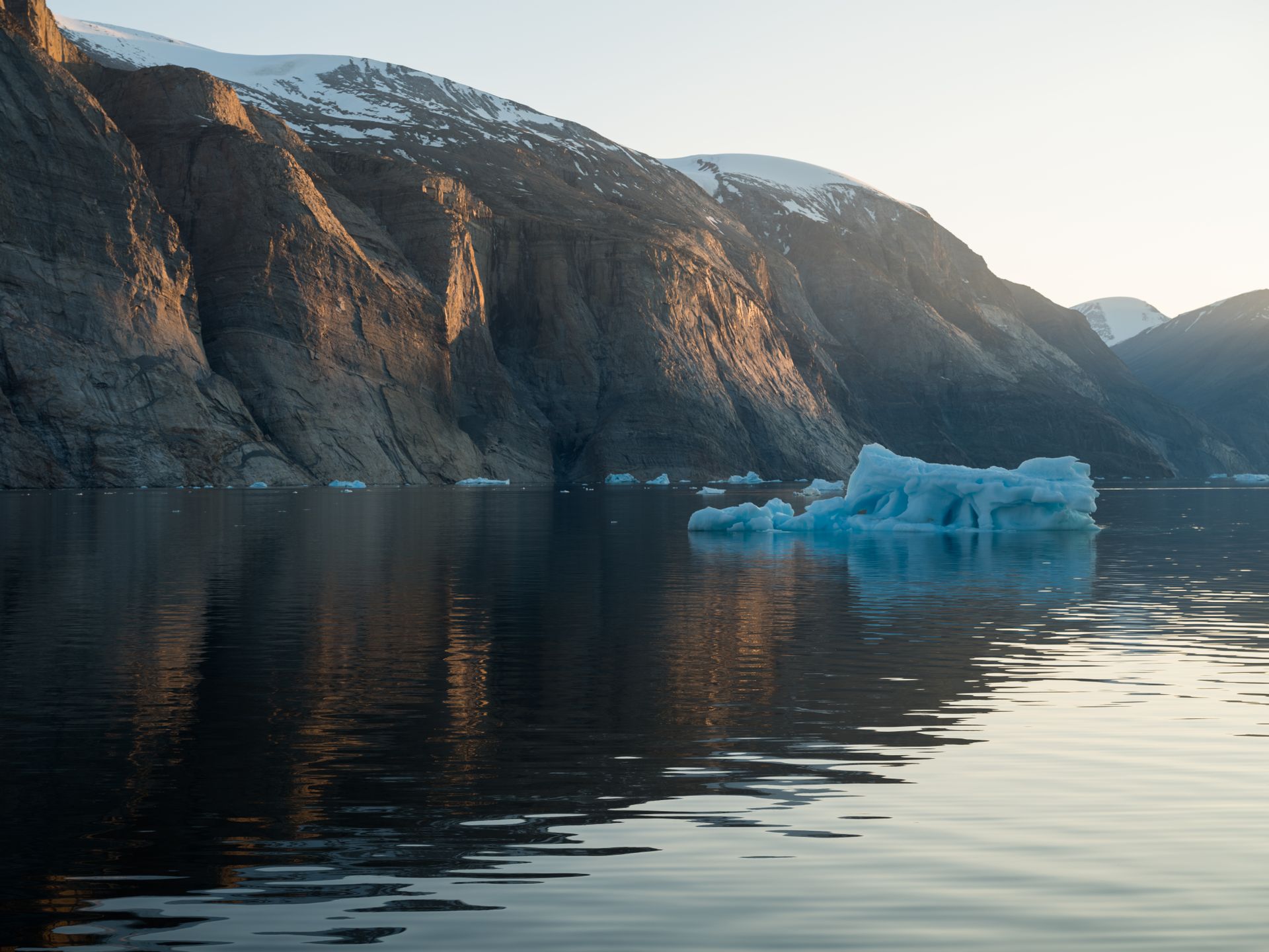 Greenland fjord with steep cliffs and a retreating glacier