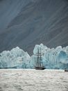 A Sailboat Near the Icebergs in the Water