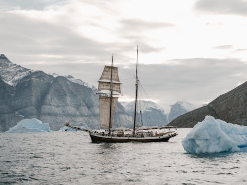 Free Brown and White Boat on Sea Near Icebergs Stock Photo