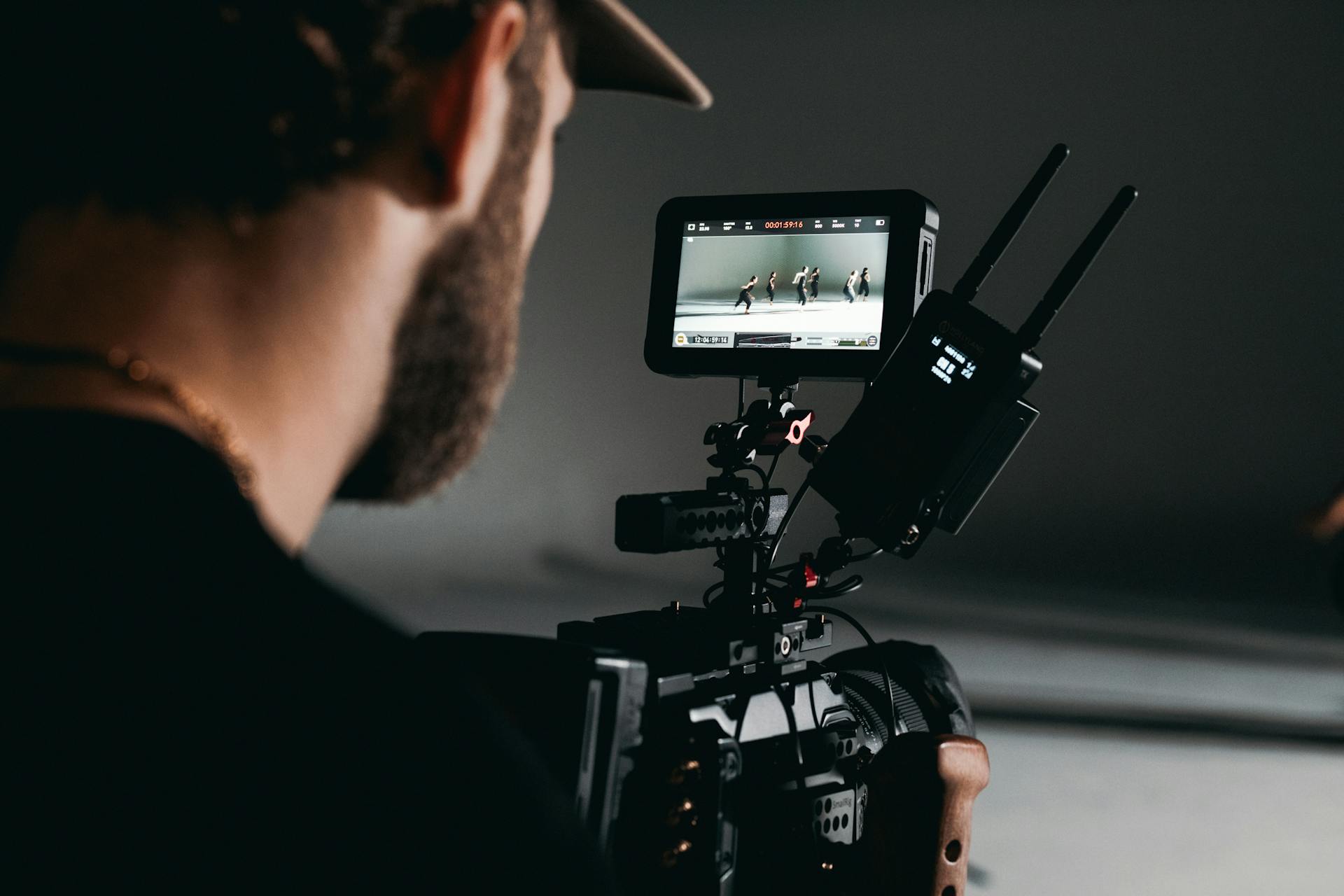 A Man Holding a Video Camera with a Monitor and Wireless Transmitter