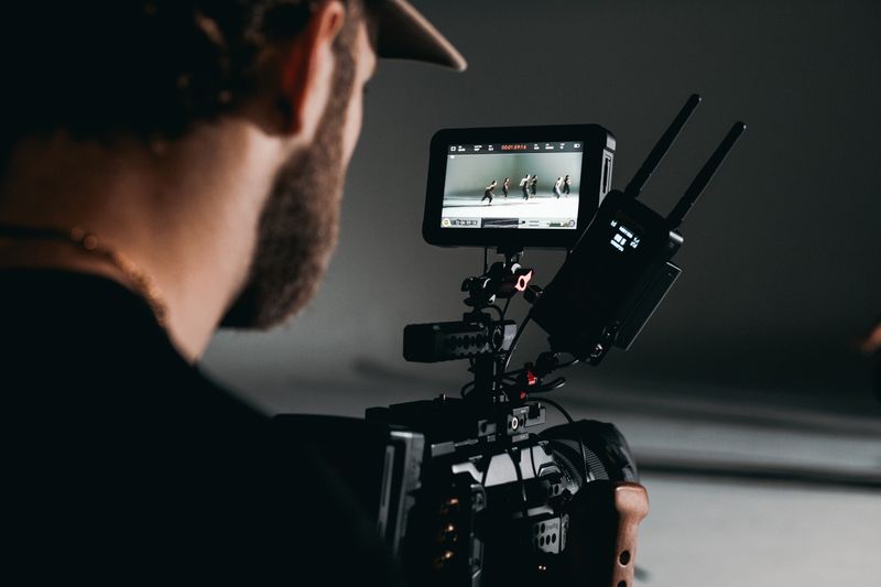 Camarógrafo de camisa negra operando cámara de cine