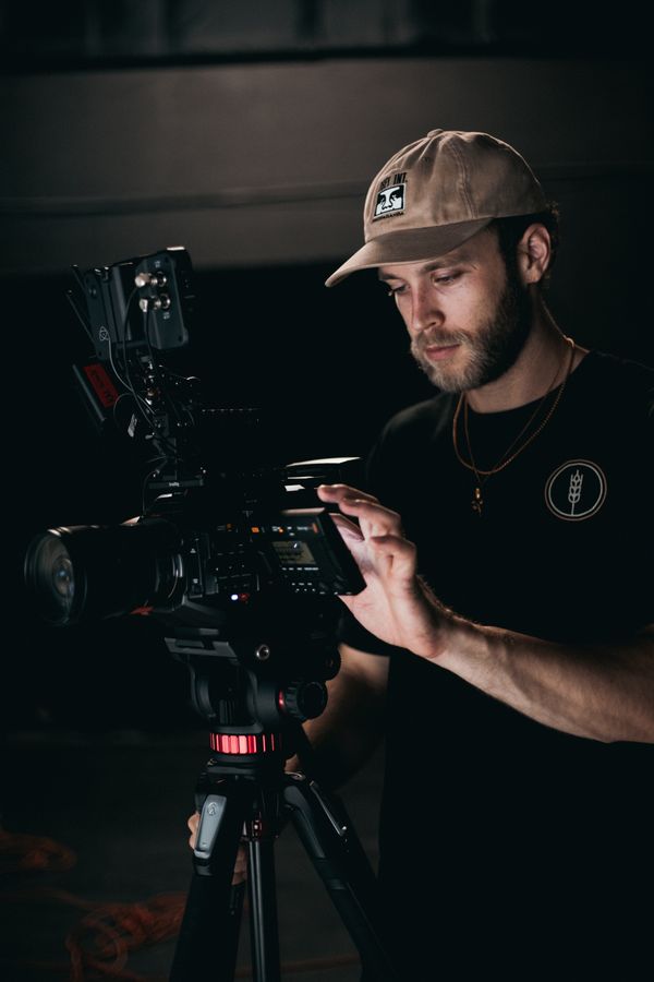 Cinematographer adjusting a camera on tripod