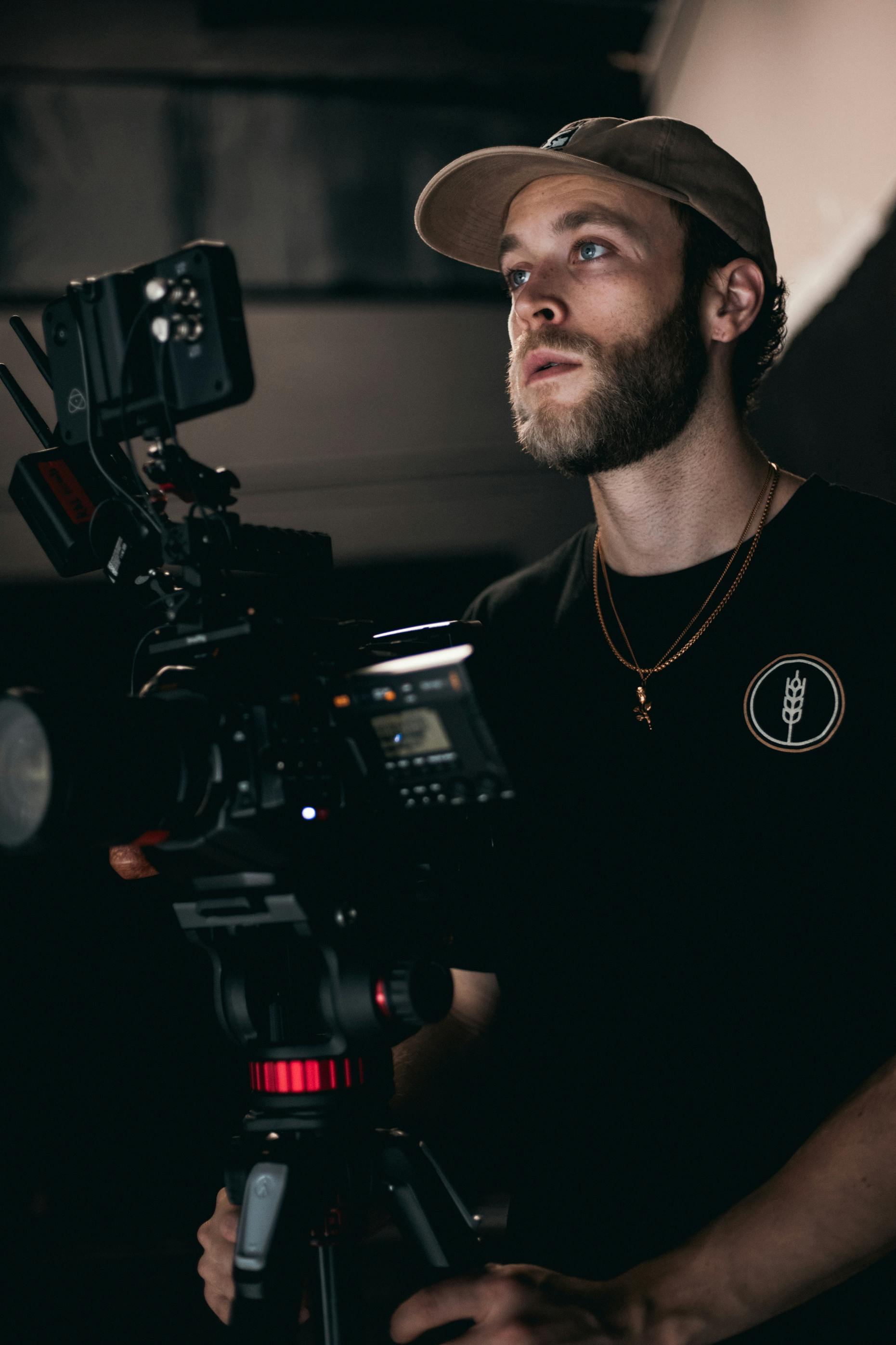 man in black crew neck shirt holding black video camera