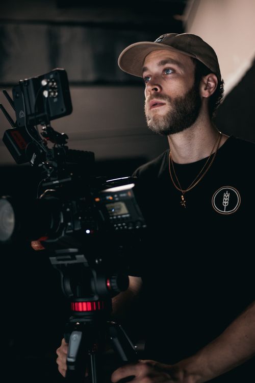 Free Cinematographer in studio setting, operating camera rig for film production. Stock Photo