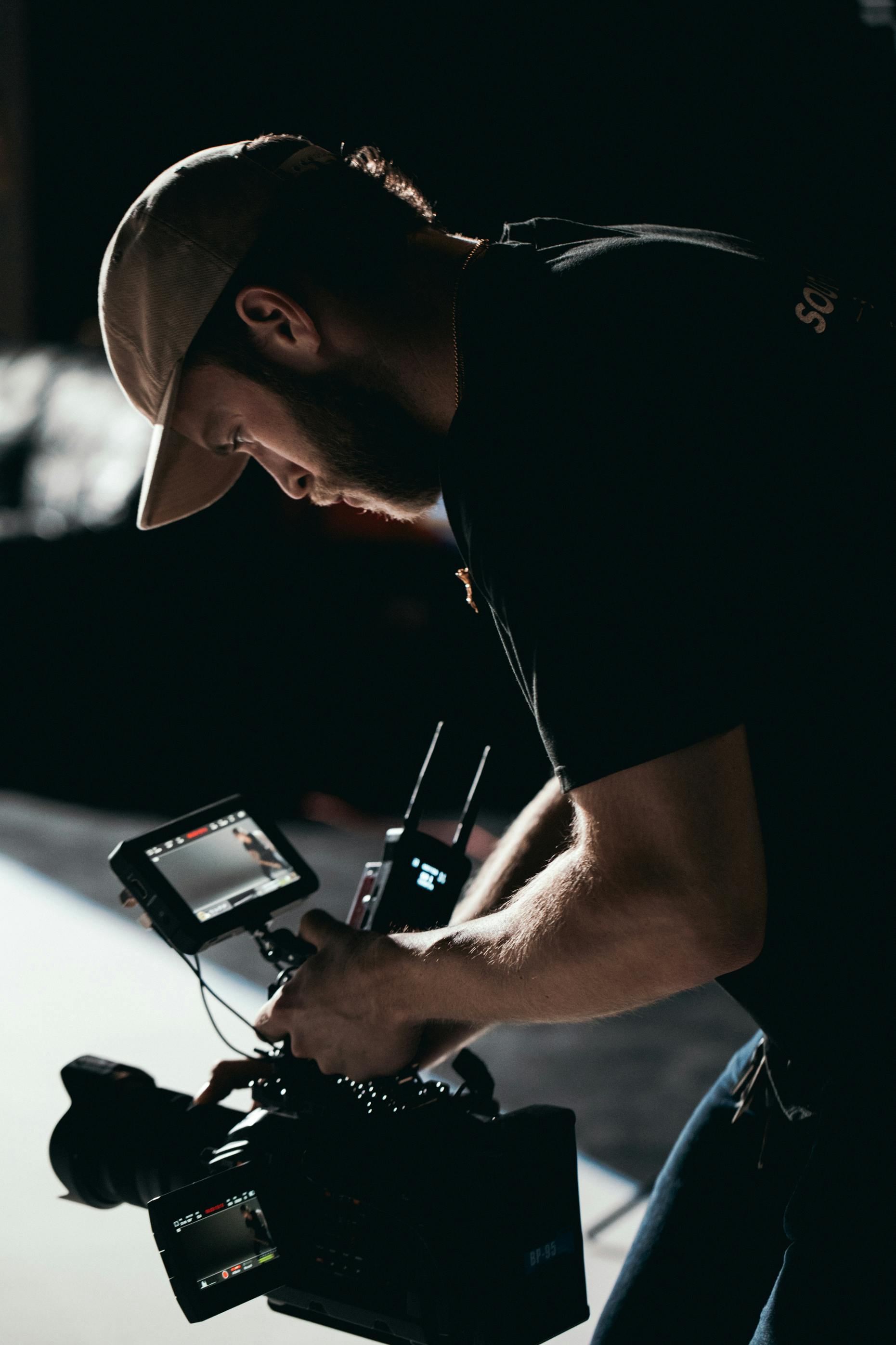 man in black t shirt holding black digital camera