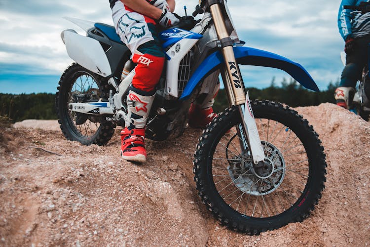 Crop Man Sitting On Enduro Motorcycle