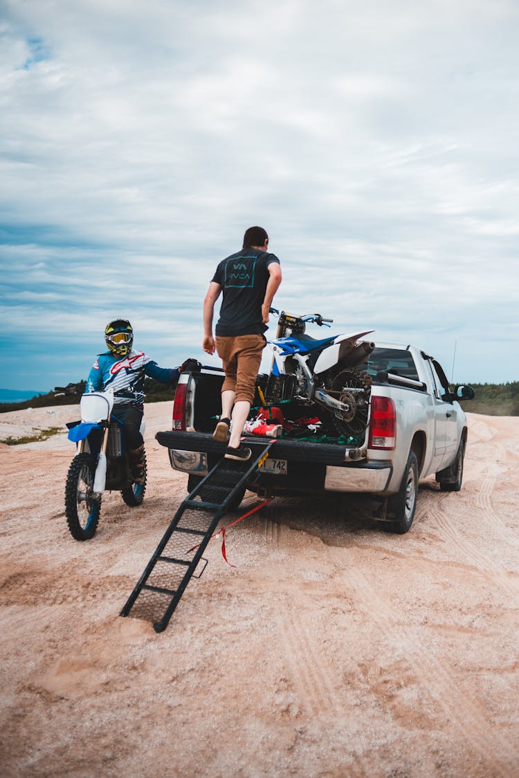 Anonymous Men Loading Motorcycle In Car