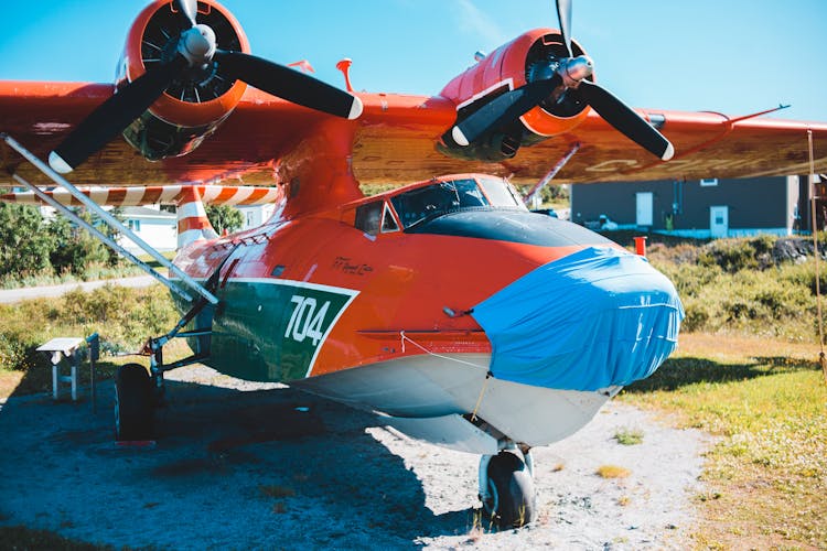 Modern Red Airplane Parked On Airfield