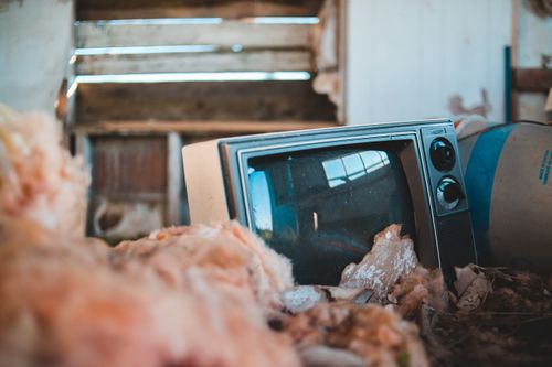 Free Ground level of retro television placed between various old objects in rural abandoned house in sunlight Stock Photo