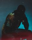 Faceless man in black sack on head in dark room