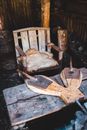 Shabby wooden chair and blacksmith board in abandoned house