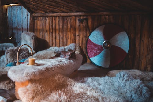 Interior of old wooden Viking house with furniture covered with natural fur in Norstead Village in Newfoundland