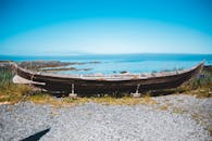 Aged boat on coast with blue ocean