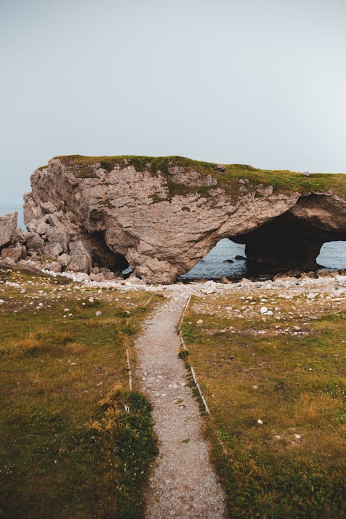 Calm shore with walkway and cliff arch