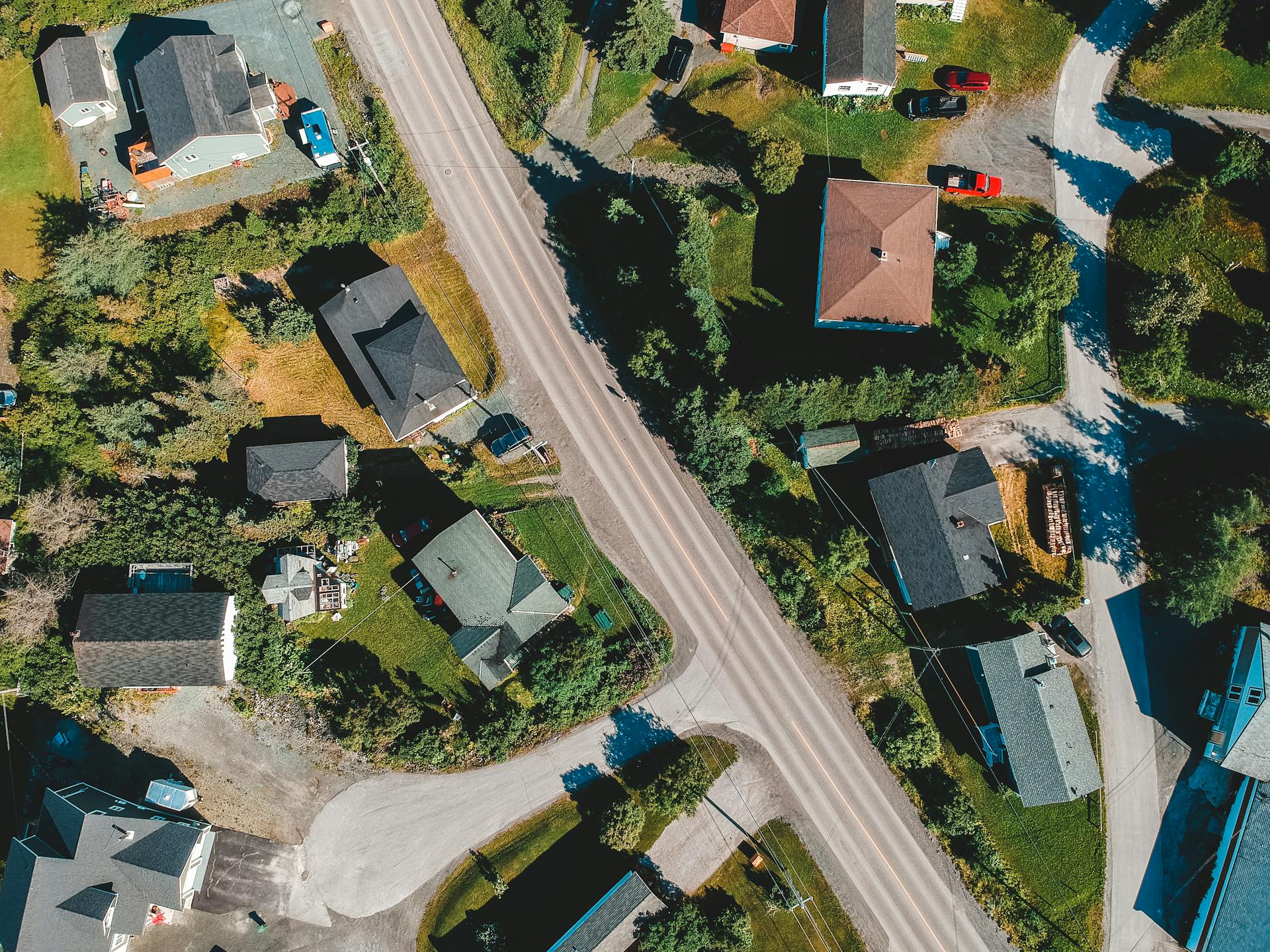 Drone view of housetops along roadway in settlement