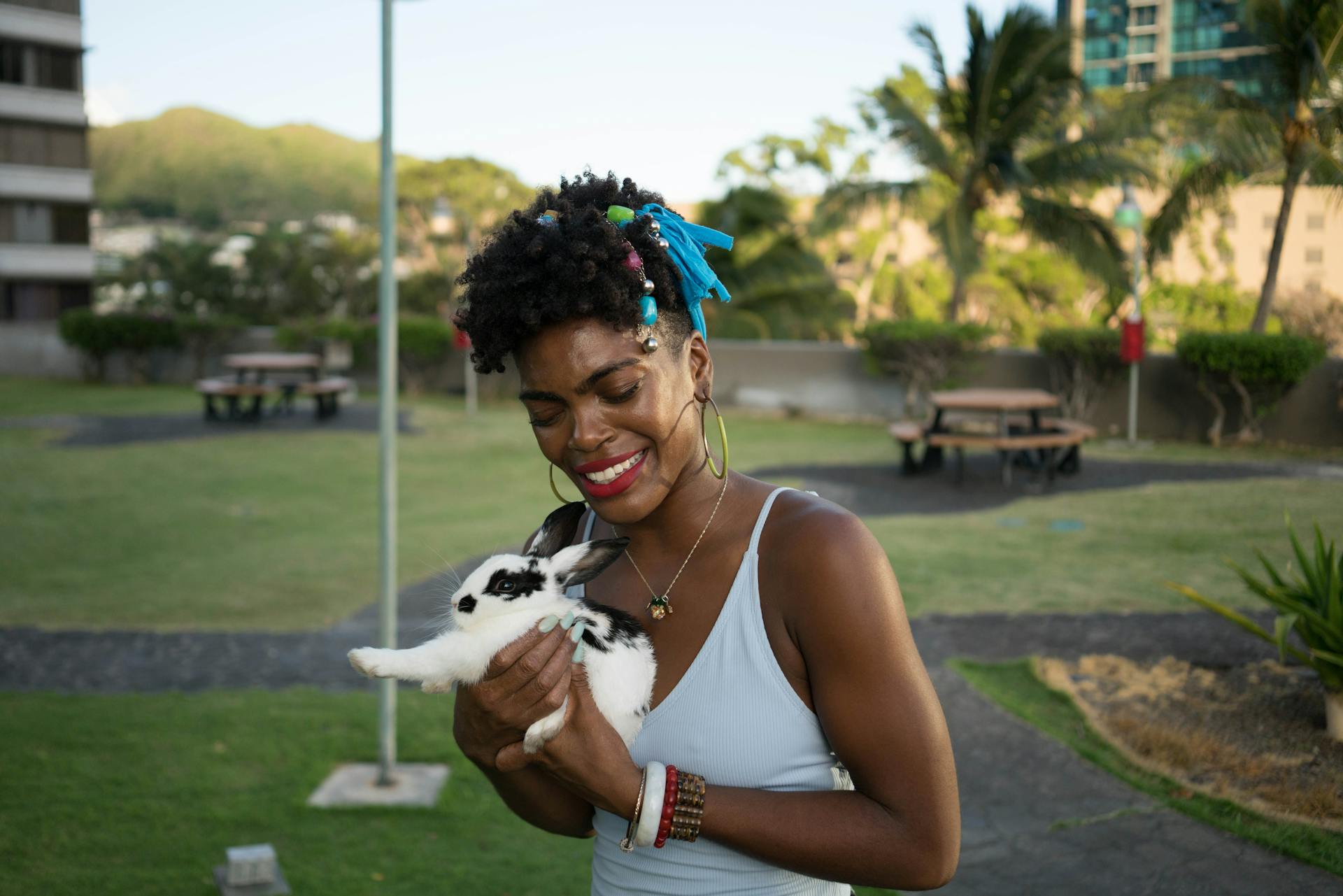 Black smiling woman hugging cute rabbit